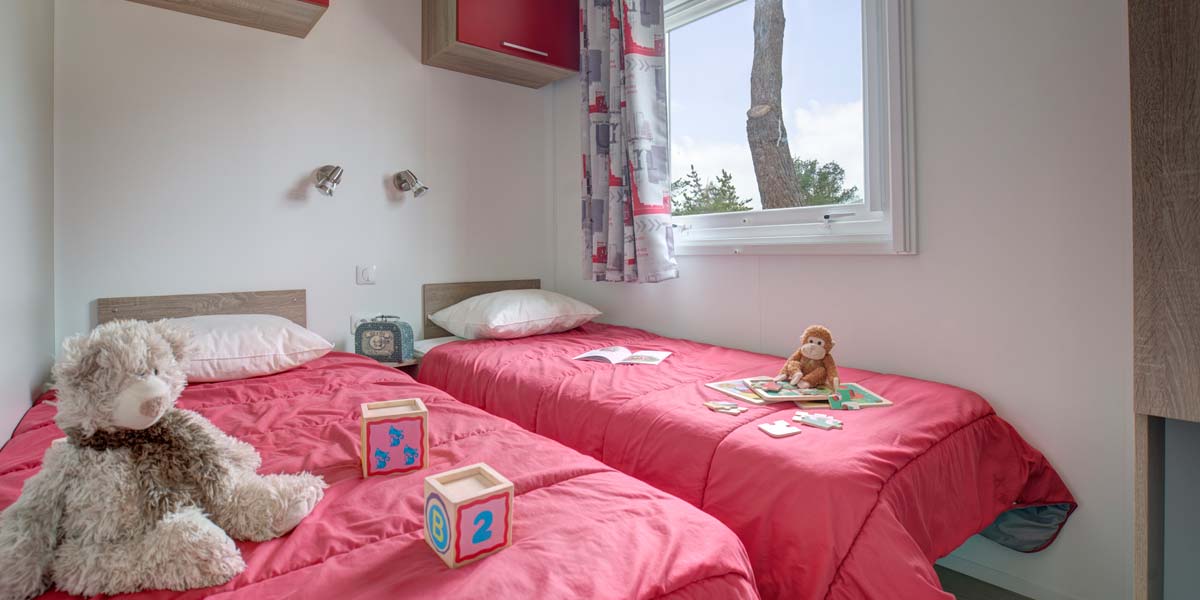 Kinderkamer met twee eenpersoonsbedden in de stacaravan in Zuid-Bretagne