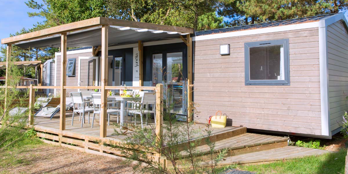 Exterior view of the covered wooden terrace of the Premium 40 mobile home at Le Fief campsite