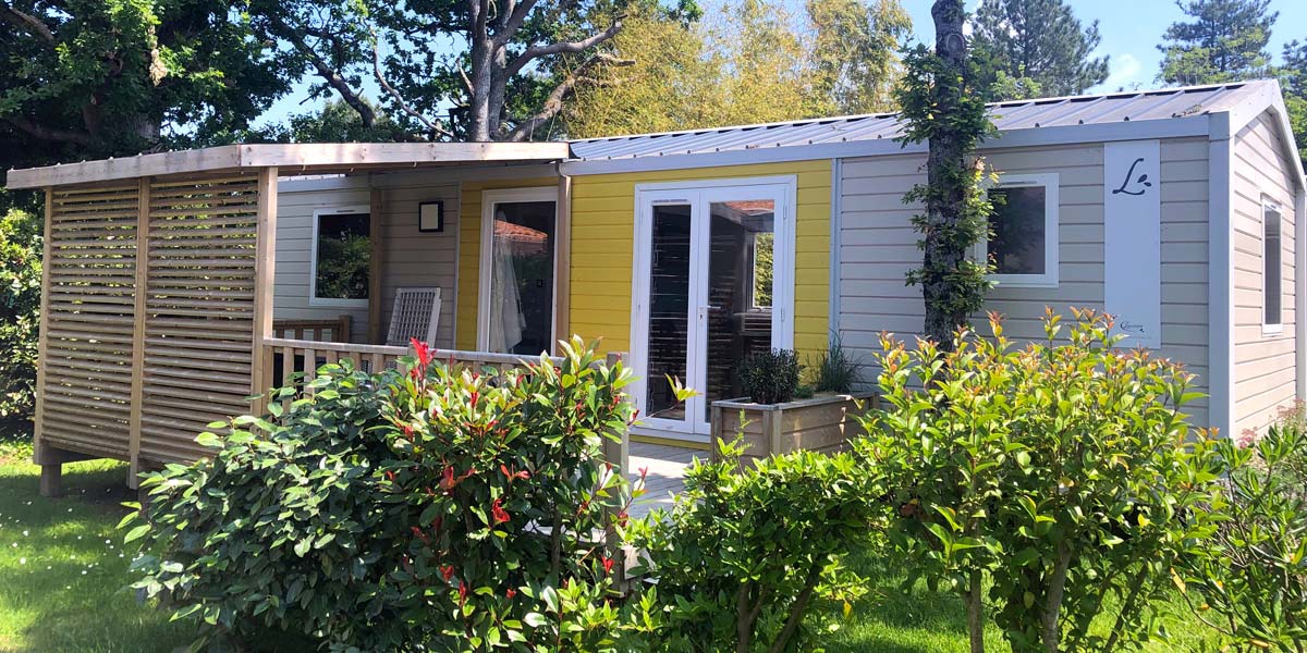 Vue extérieure du mobil-home Corail et des espaces verts au camping Le Fief