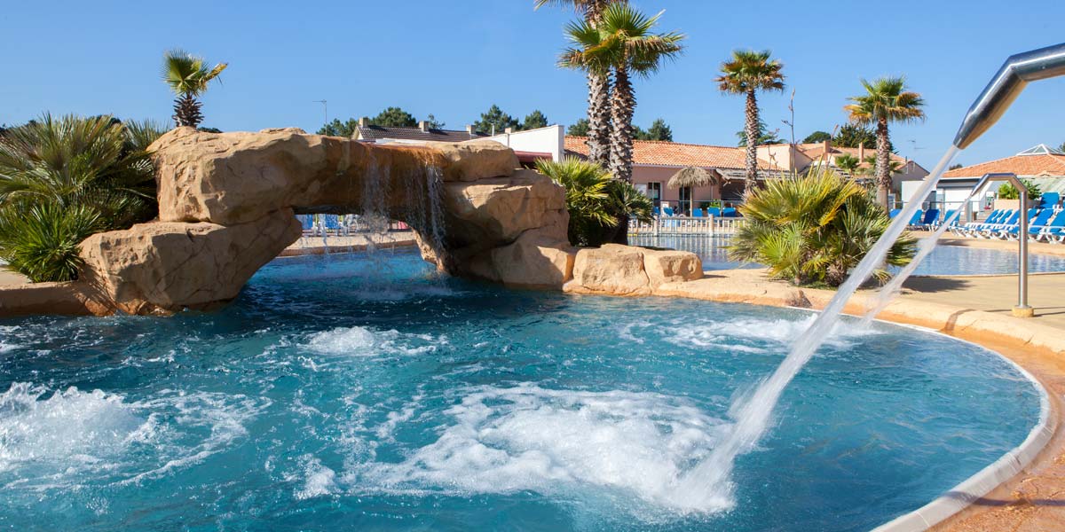 La piscine avec jets bouillonnants et des transats à Saint-Brevin