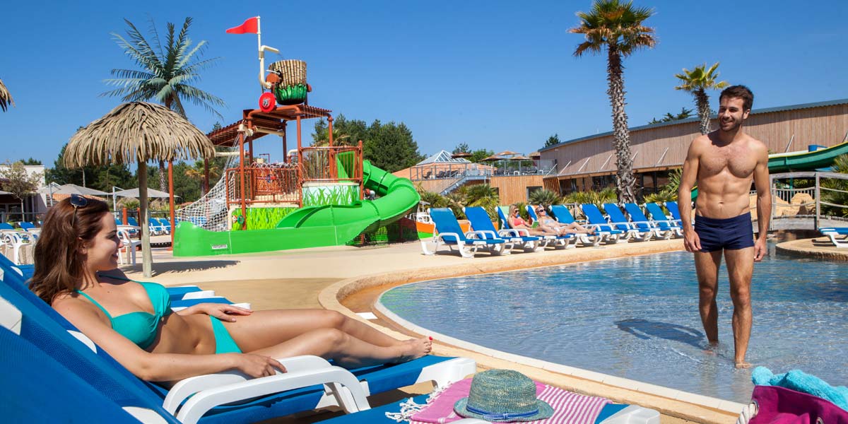 Plage de la piscine avec des transats au camping Le Fief à Saint-Brevin