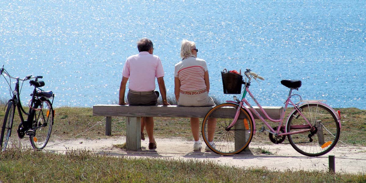 Ein paar Radfahrer sitzen auf einer Bank in Saint-Brevin in der Nähe des Campingplatzes Le Fief