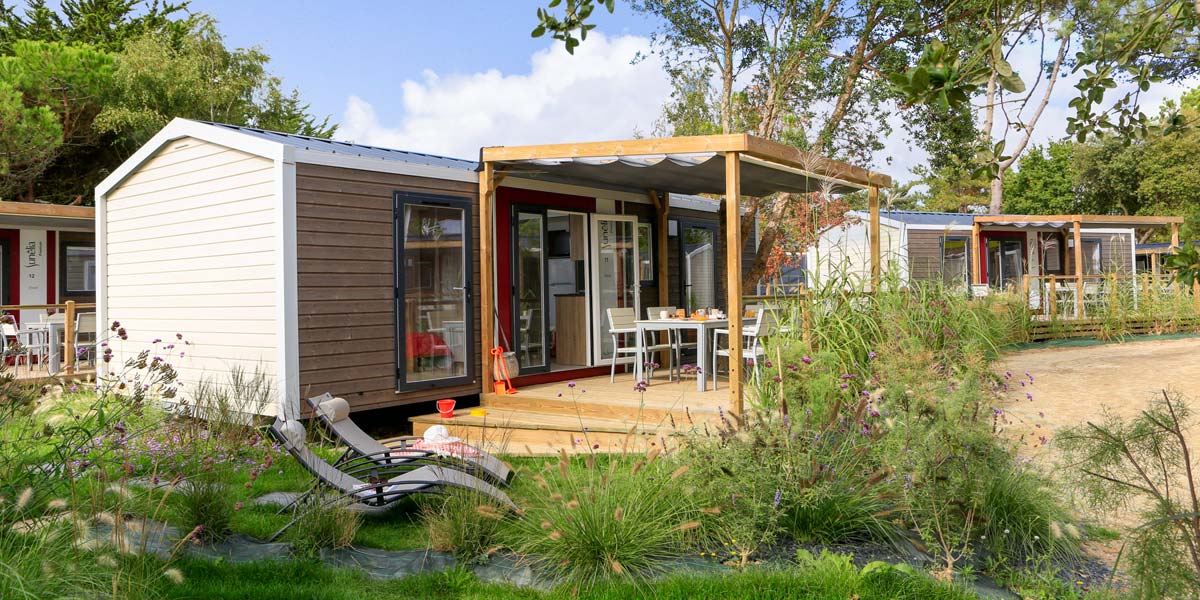 Ligstoelen, vegetatie en terras van een stacaravan in Zuid-Bretagne