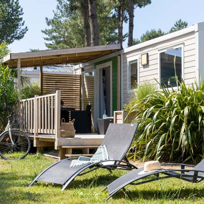 Halb überdachte Holzterrasse eines komfortablen Mobilheims auf dem Campingplatz Le Fief